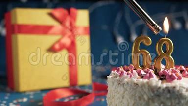 白色生日蛋糕数字68金色蜡烛用打火机燃烧，蓝色背景灯和礼品黄色盒子用红色系起来